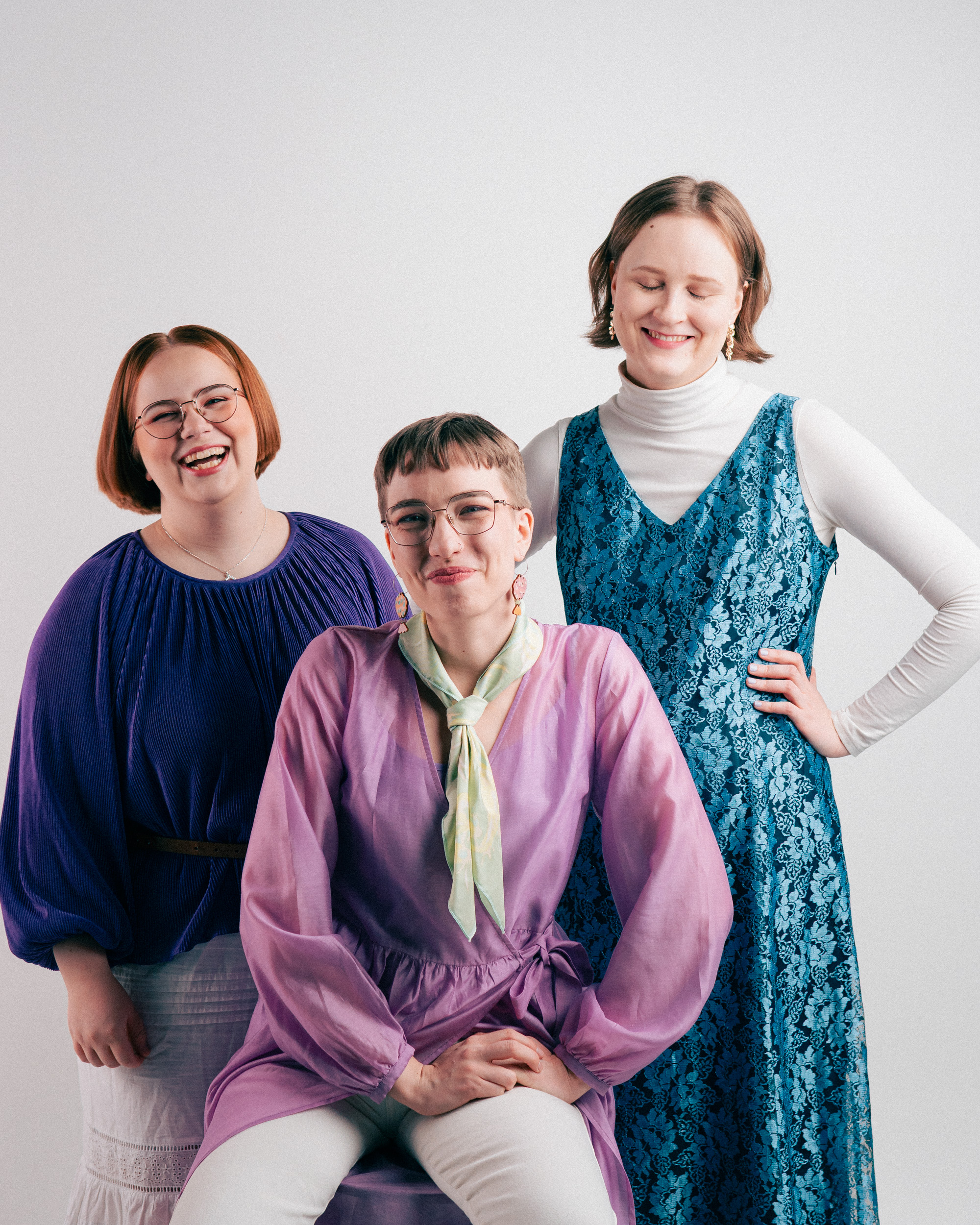 Freeta-yhtye poseeraa rennosti hymyillen valkoisen taustan edessä.