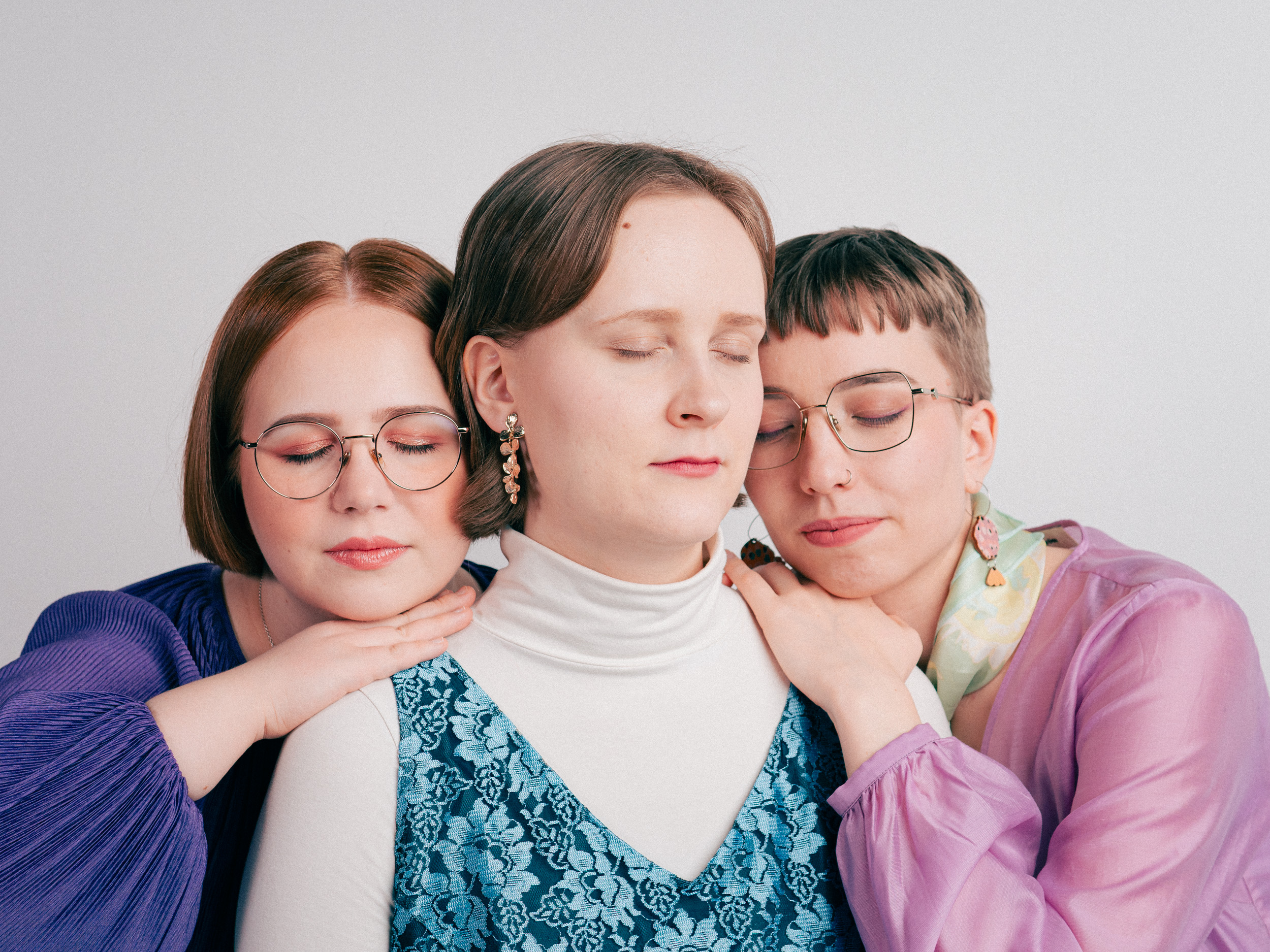 Freeta-yhtye vaalealla taustalla silmät kiinni.