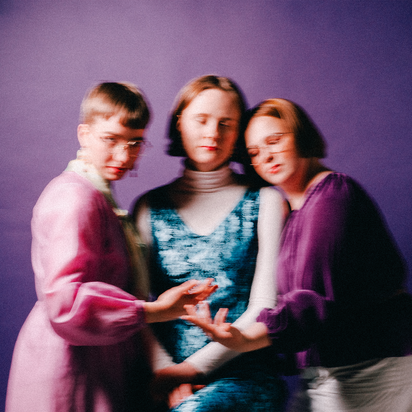 Tummanvioletin taustan edessä Freeta-yhtyeen jäsenet. Valokuva on tärähtänyt ja kuvassa utuinen tunnelma. Osalla on kuvassa silmät kiinni.